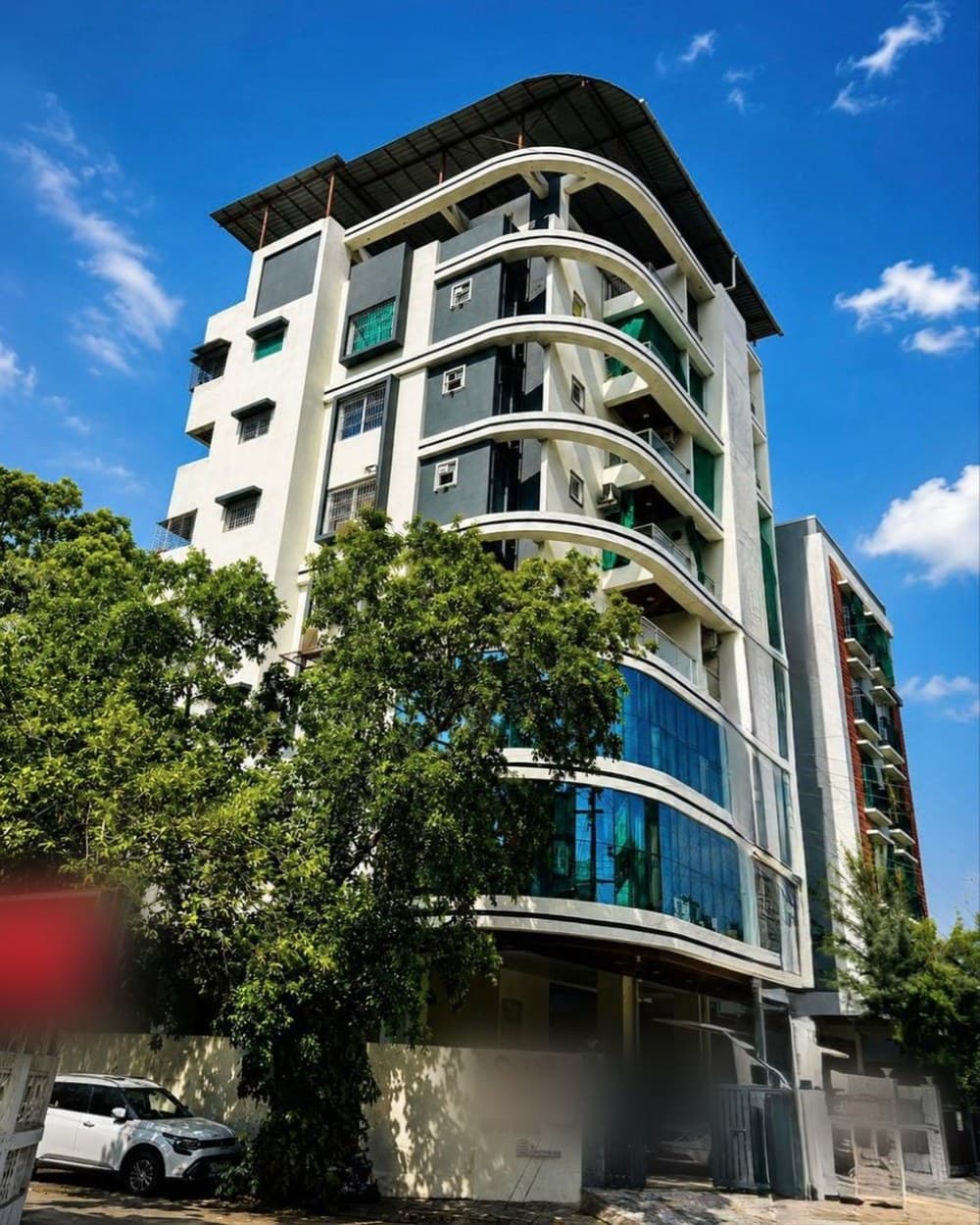 A glass-fronted apartment block — the same building, finished