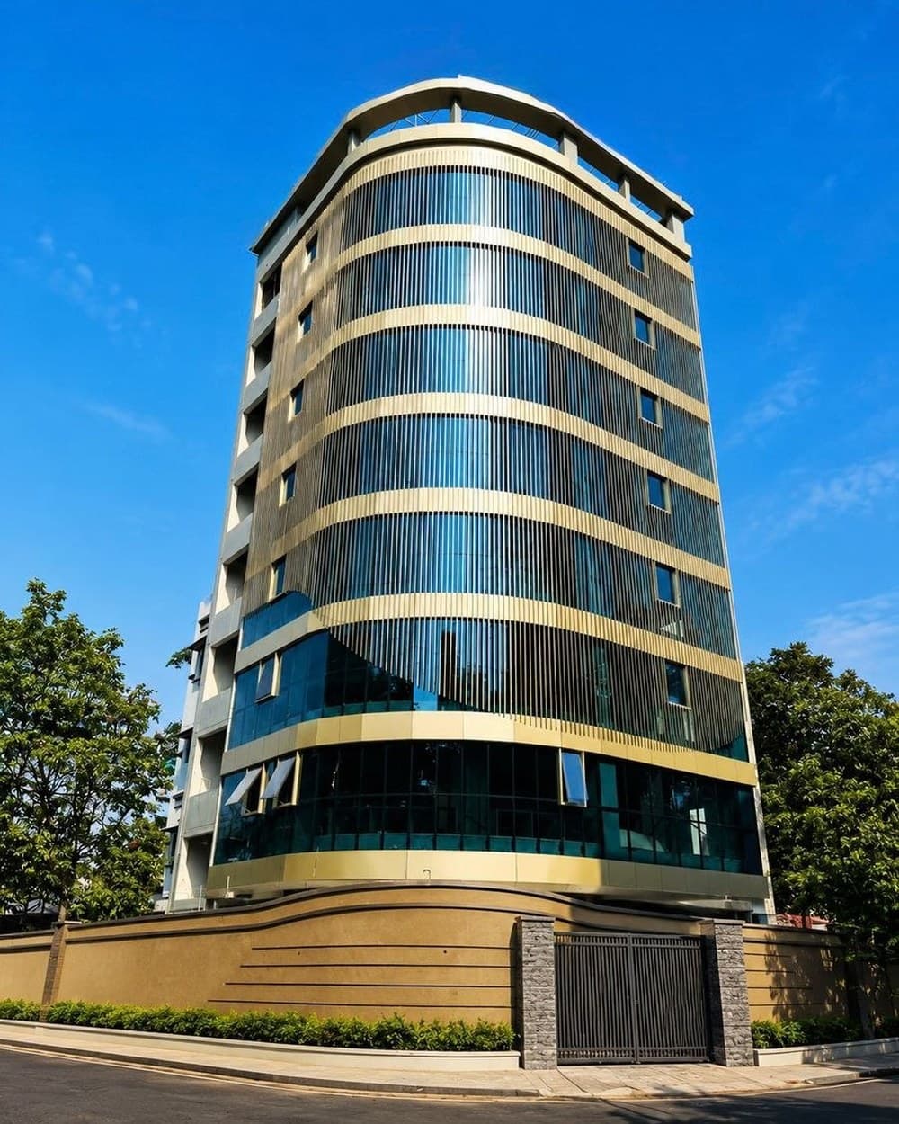 A curved tower, still under construction — the same building, finished